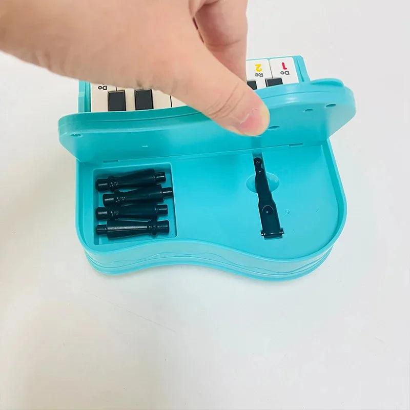 A handheld mini desktop piano with lights, music, electronic keyboard rhythm, and a game console for completing levels; a Montes